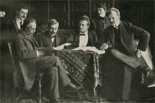 Max und  mit (v.l.n.r.) Theodor Müller-Reuter, Max Hehemann,  und  in Essen 1905 über der Partitur der   sitzend. –  Abgebildet in , Abb. 54.